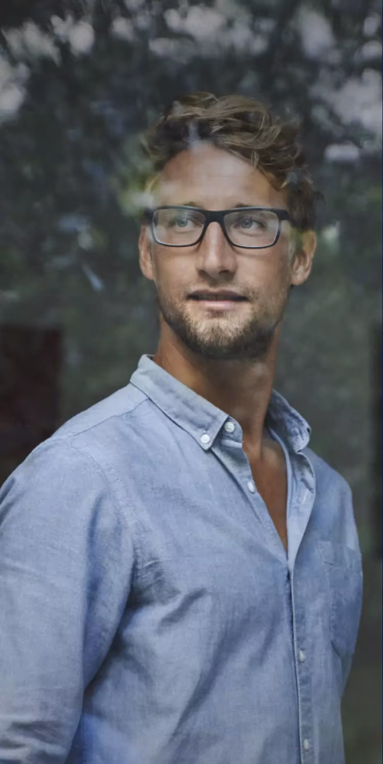 Porträt eines Mannes mit Brille und hellblauem Hemd