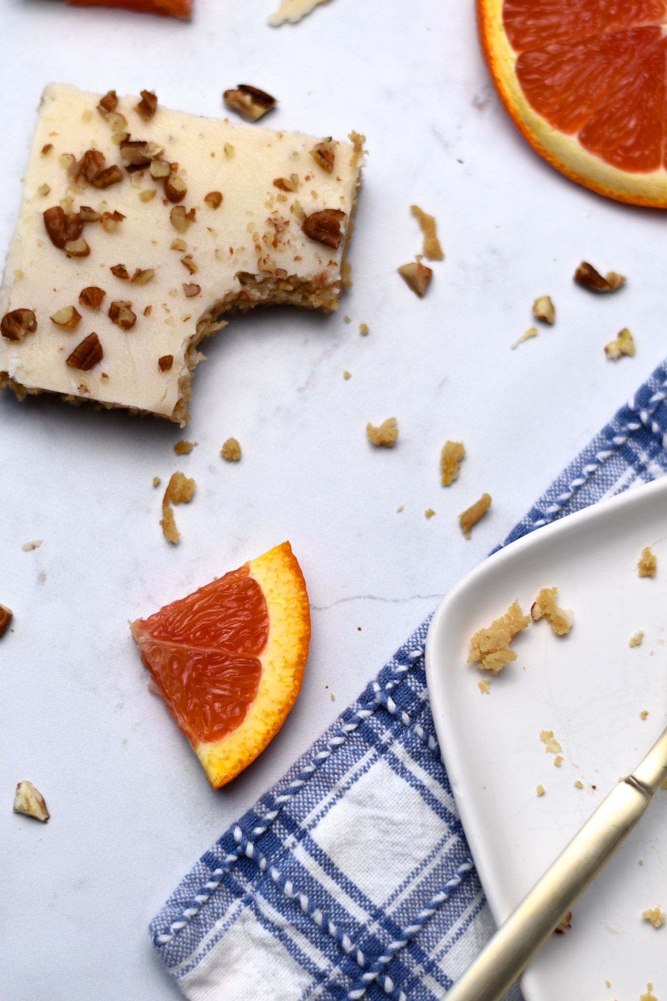 A slice of gluten free orange sheet cake with chopped pecans