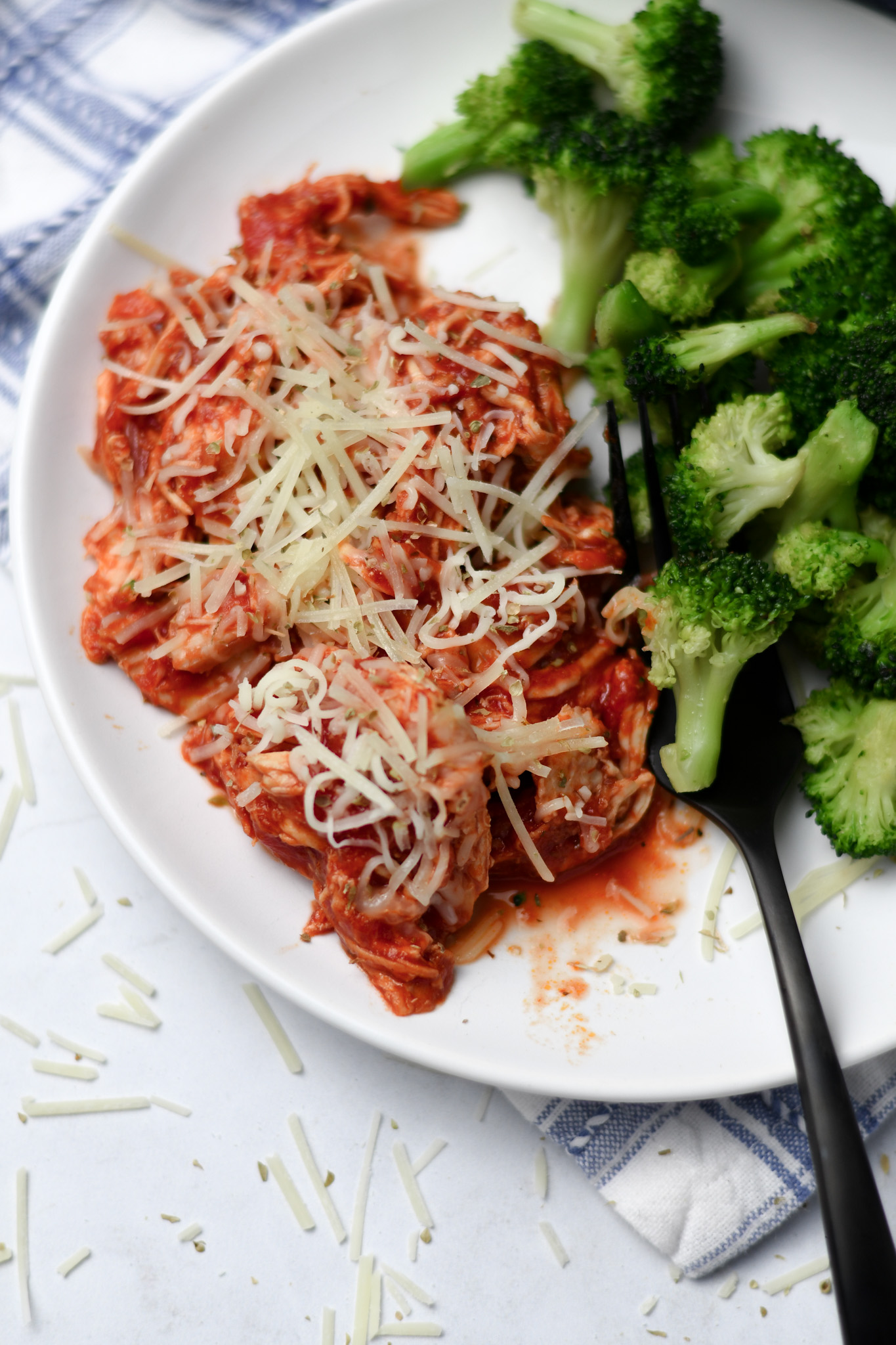 Shredded Chicken Parmesan on a White Plate with Broccoli