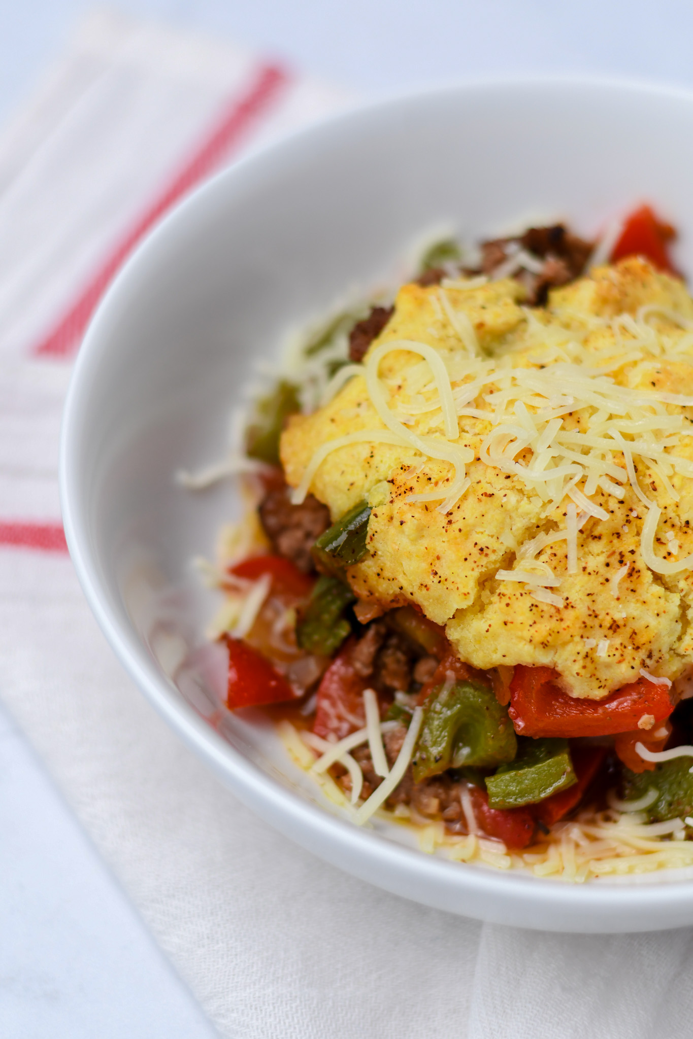 Weeknight chili in a white bowl with gluten free cornbread