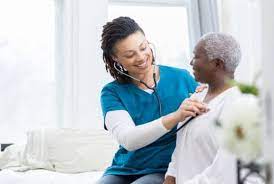 A nursing assistant checking the heartbeat of an old woman using stethoscope