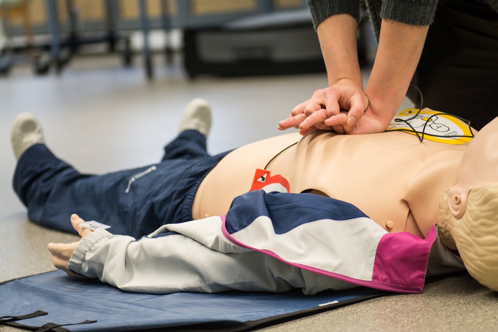 A healthcare professional performing CPR to a mannequin