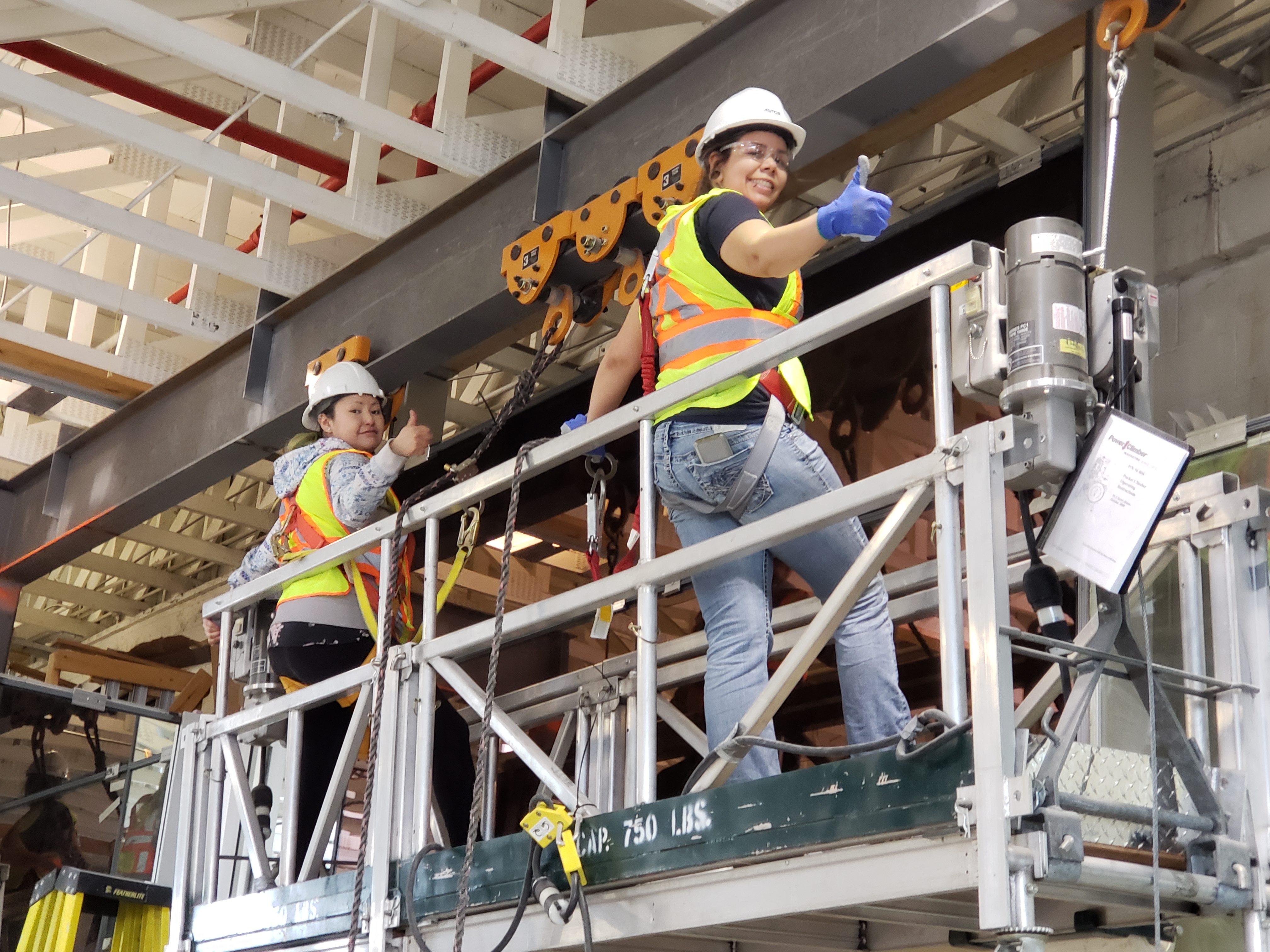 Two craftswomen wearing safety gears while doing a thumbs up