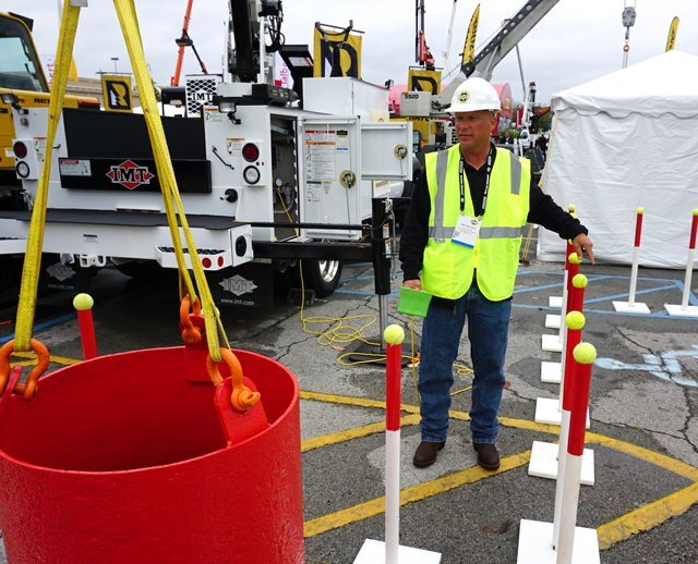 Crane Operator and Instructor maneuvers a steel weight through a course designed to test the capabilities of service truck crane operators