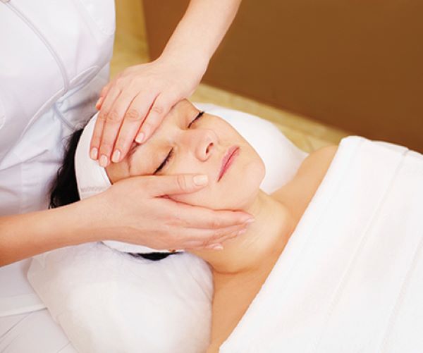 Aesthetics instructor massaging the face of a woman