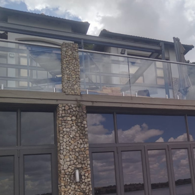 Glass balustrade with steel handrail on a patio