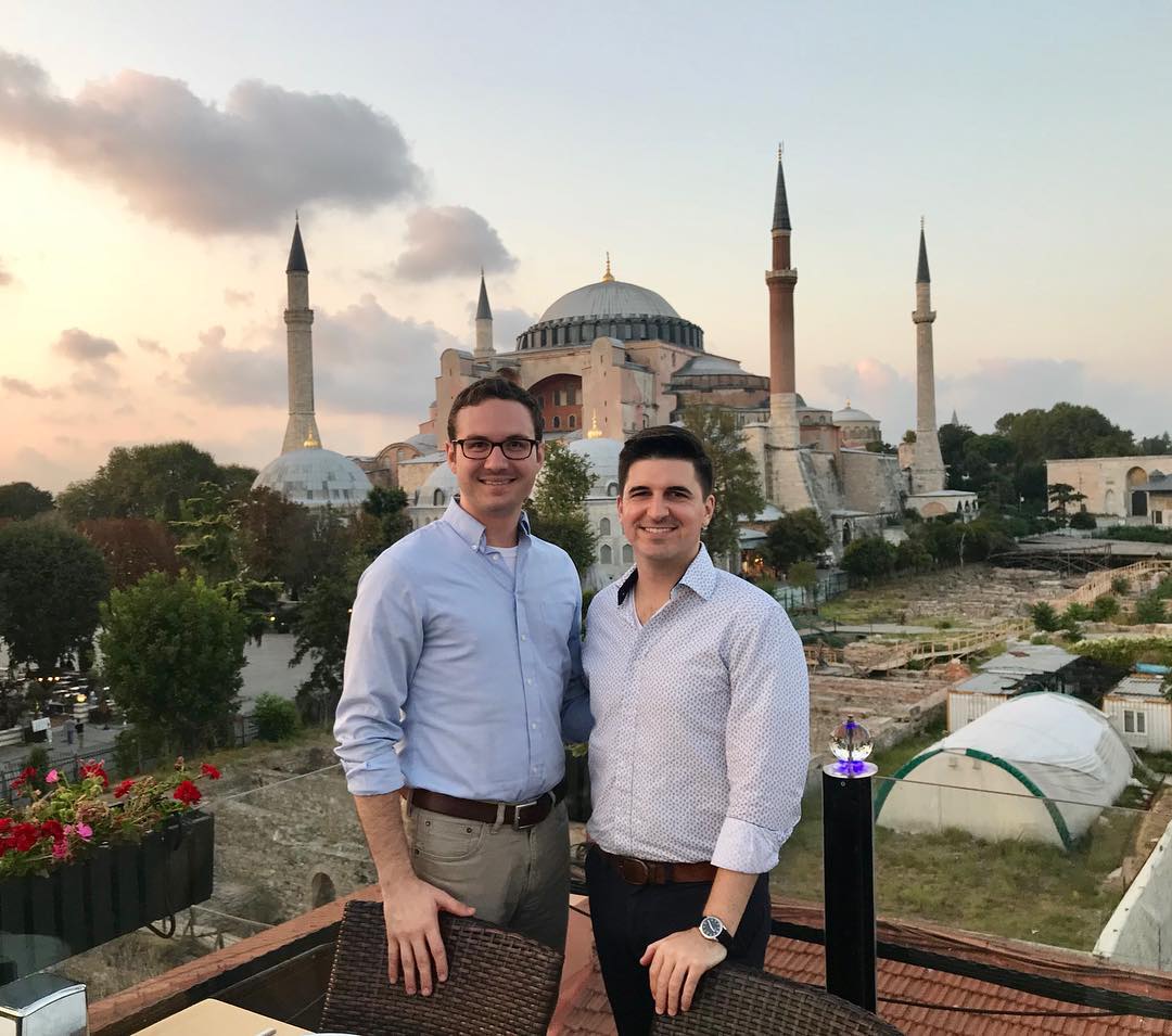 Two men standing on a balcony in Istanbul, Turkey with the Hagia Sophia in the background.