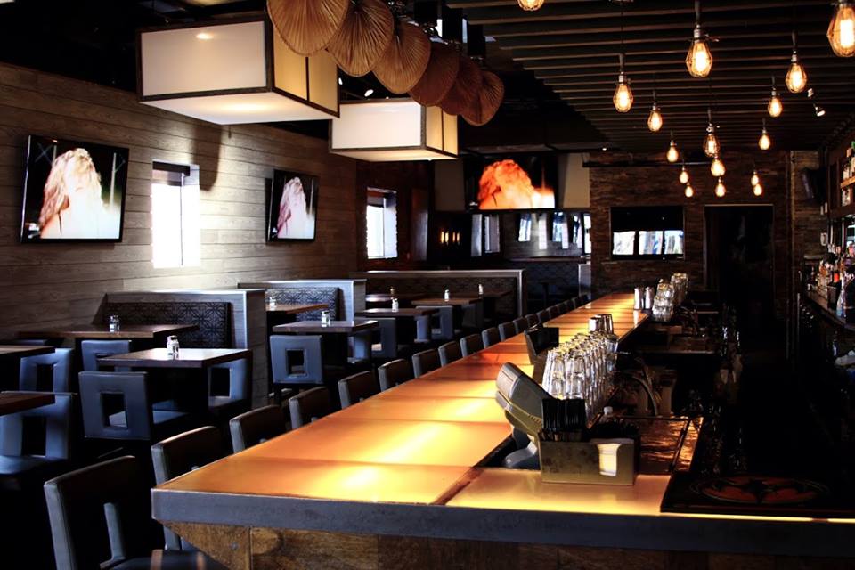 The bar at Union Cafe with seats and booths on the left.