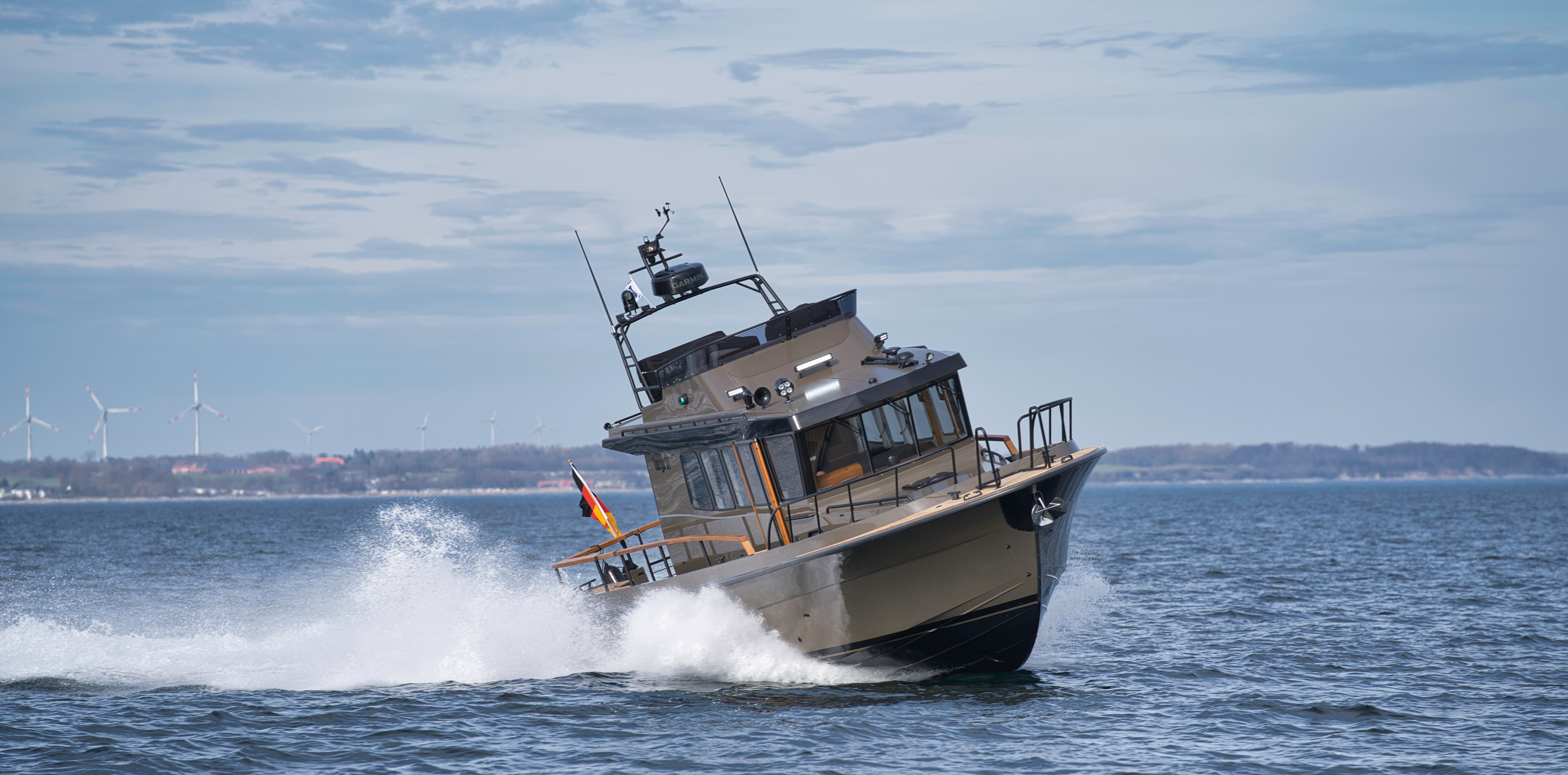 Eine Targa 37 (olivgrün) springt schnell durch die Wellen.