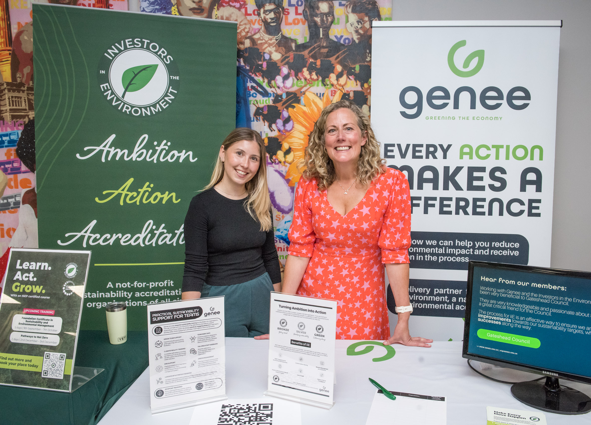 The Genee team (two consultant women) standing at a Genee stall