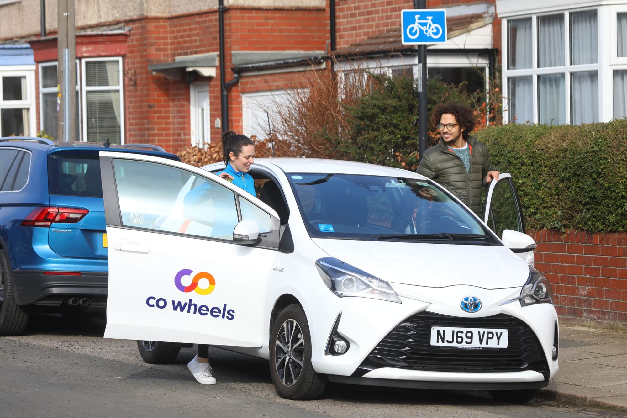 Couple getting into car club vehicle