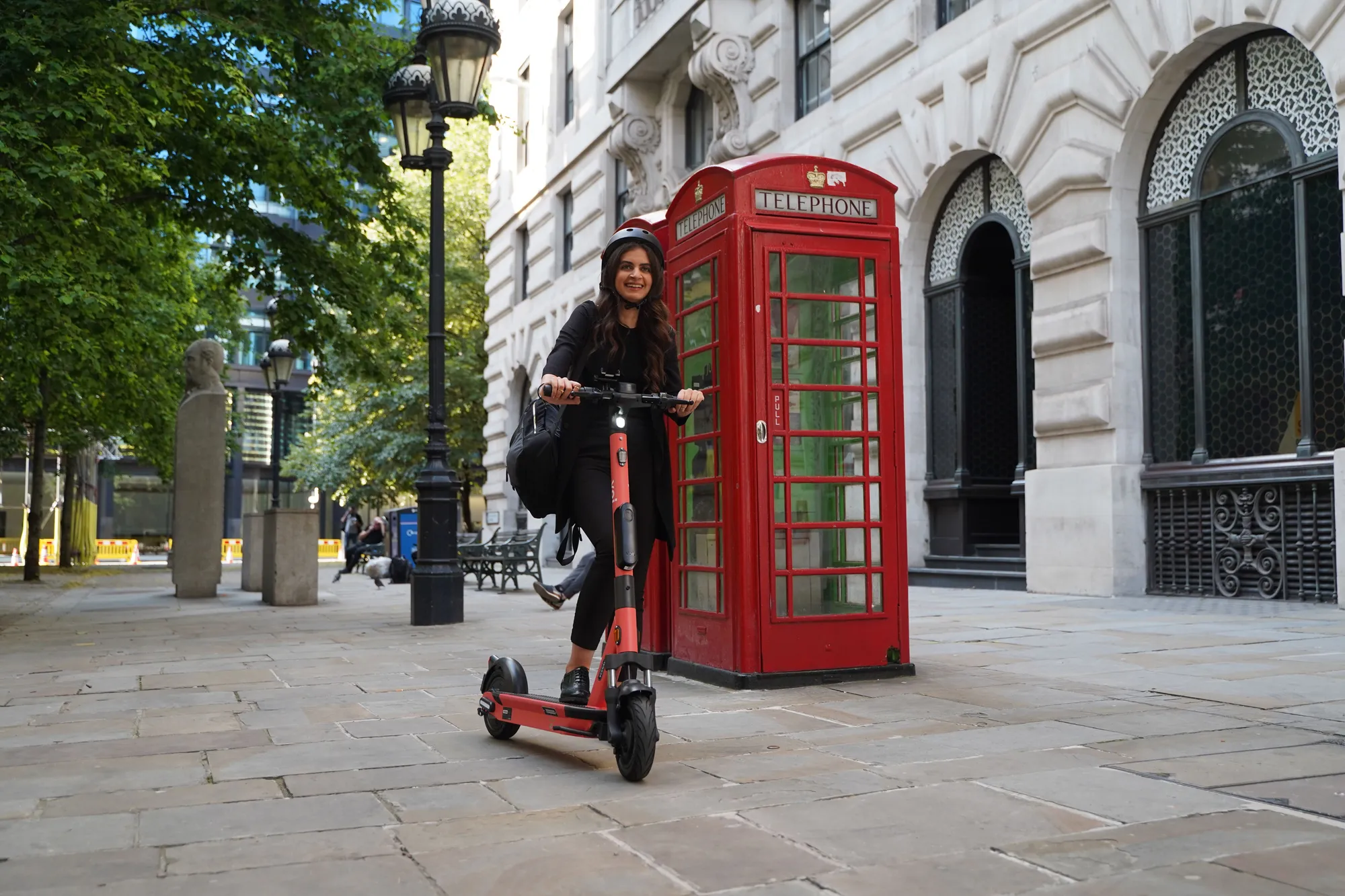Voi e-scooter in front of red phone box