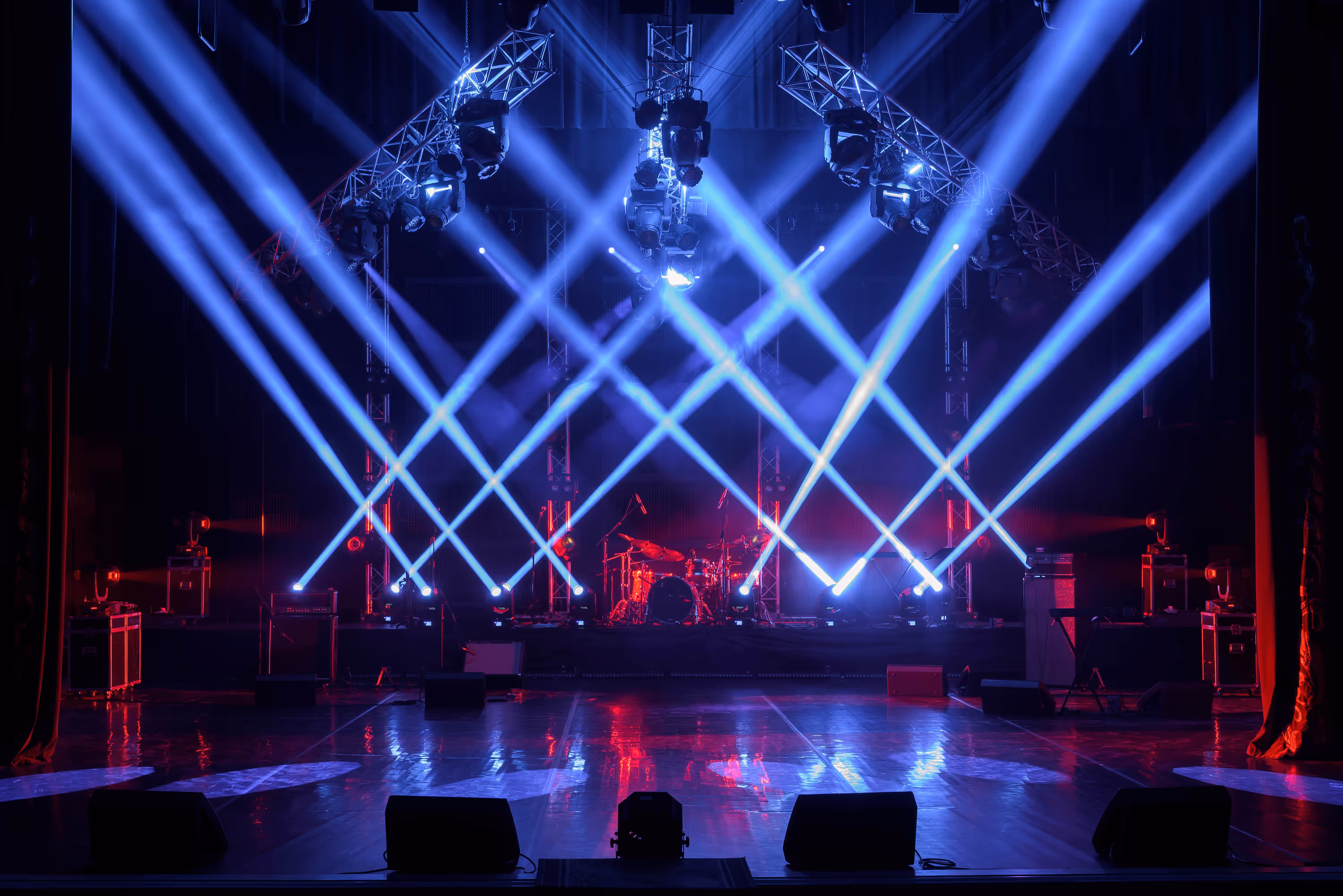 A professional event stage with dynamic lighting design, LED production, and atmospheric beam effects.