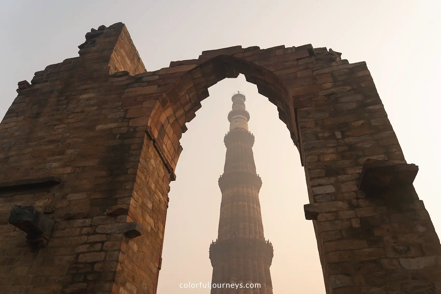 Qutub Minar framed by an arched wall in Delhi, India