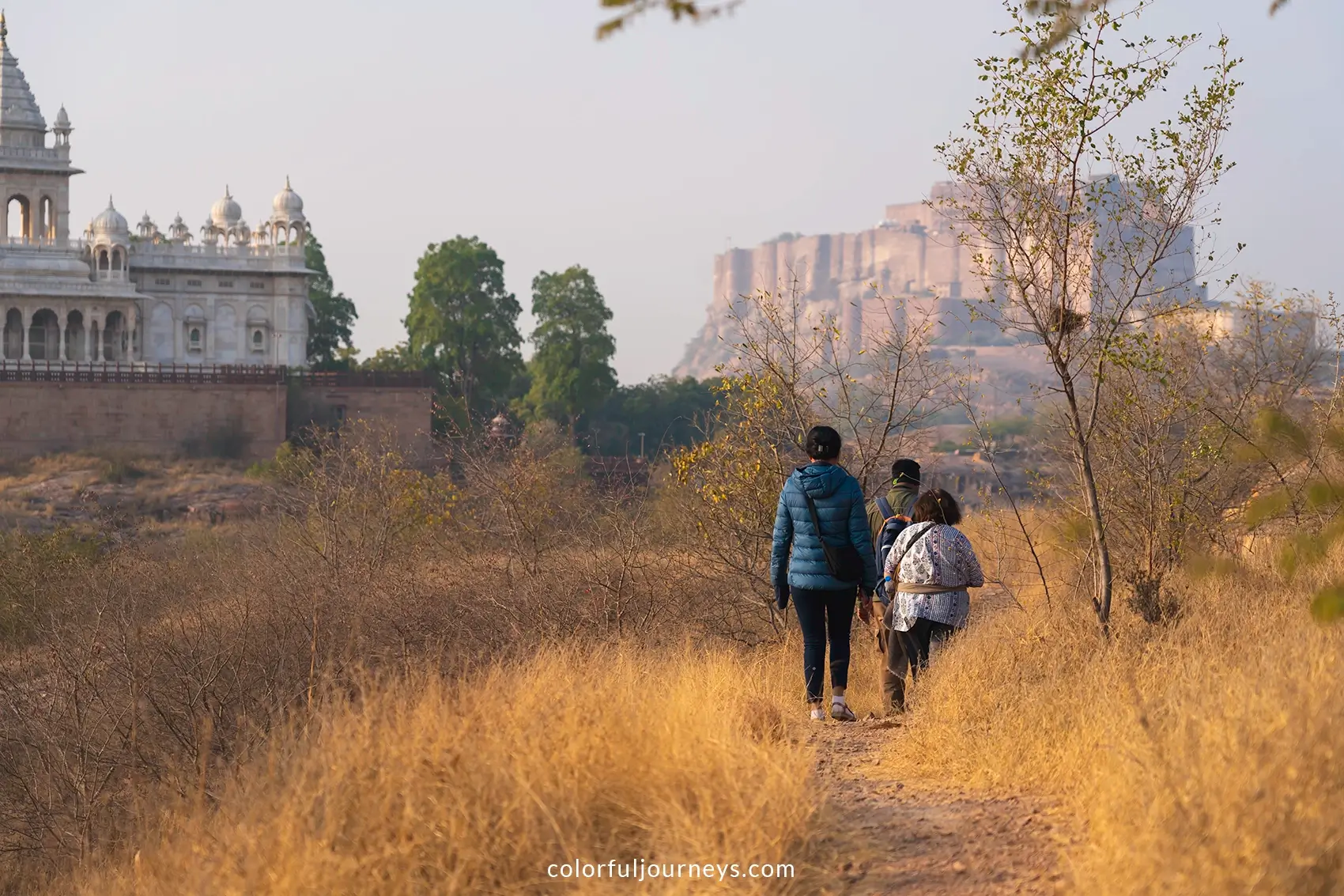 People walk through Rao Jodha rock park with Mehrangarh fort in the background in Jodhpur, India