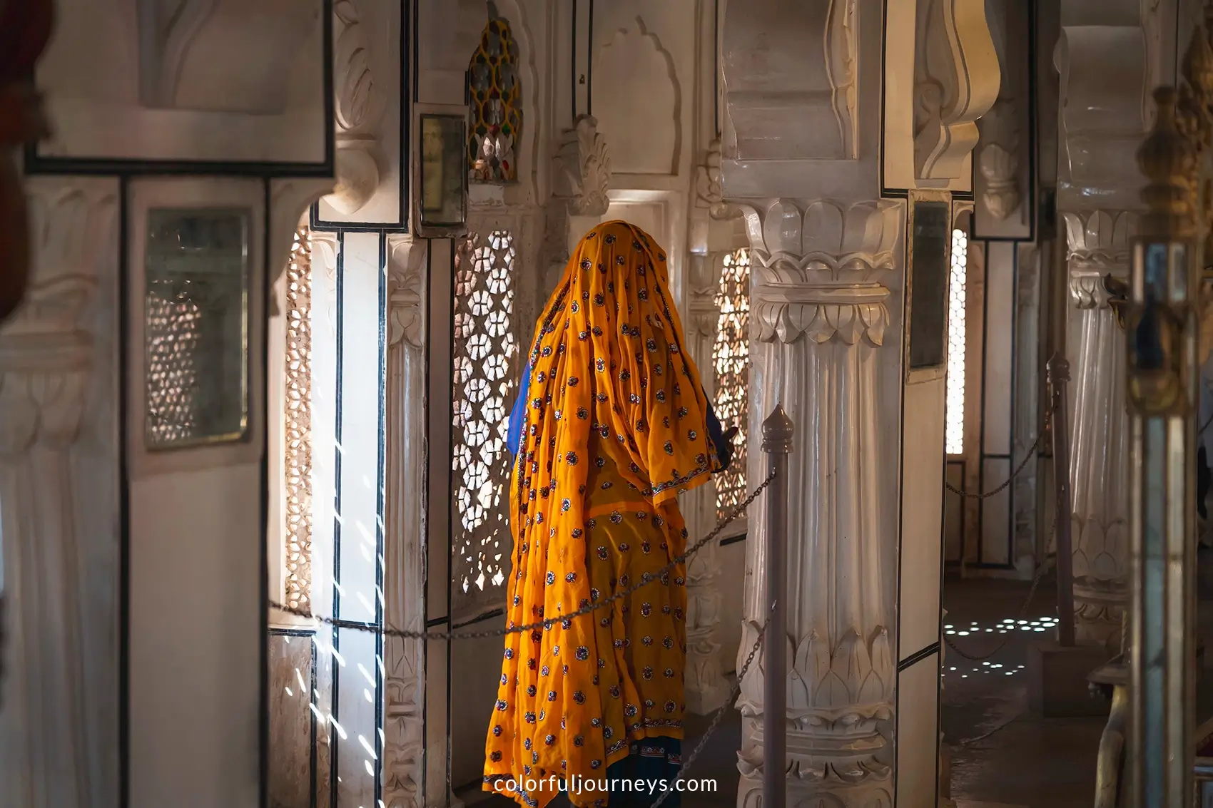 A woman wearing a sari walks around Mehrangarh Fort in Jodhpur, India