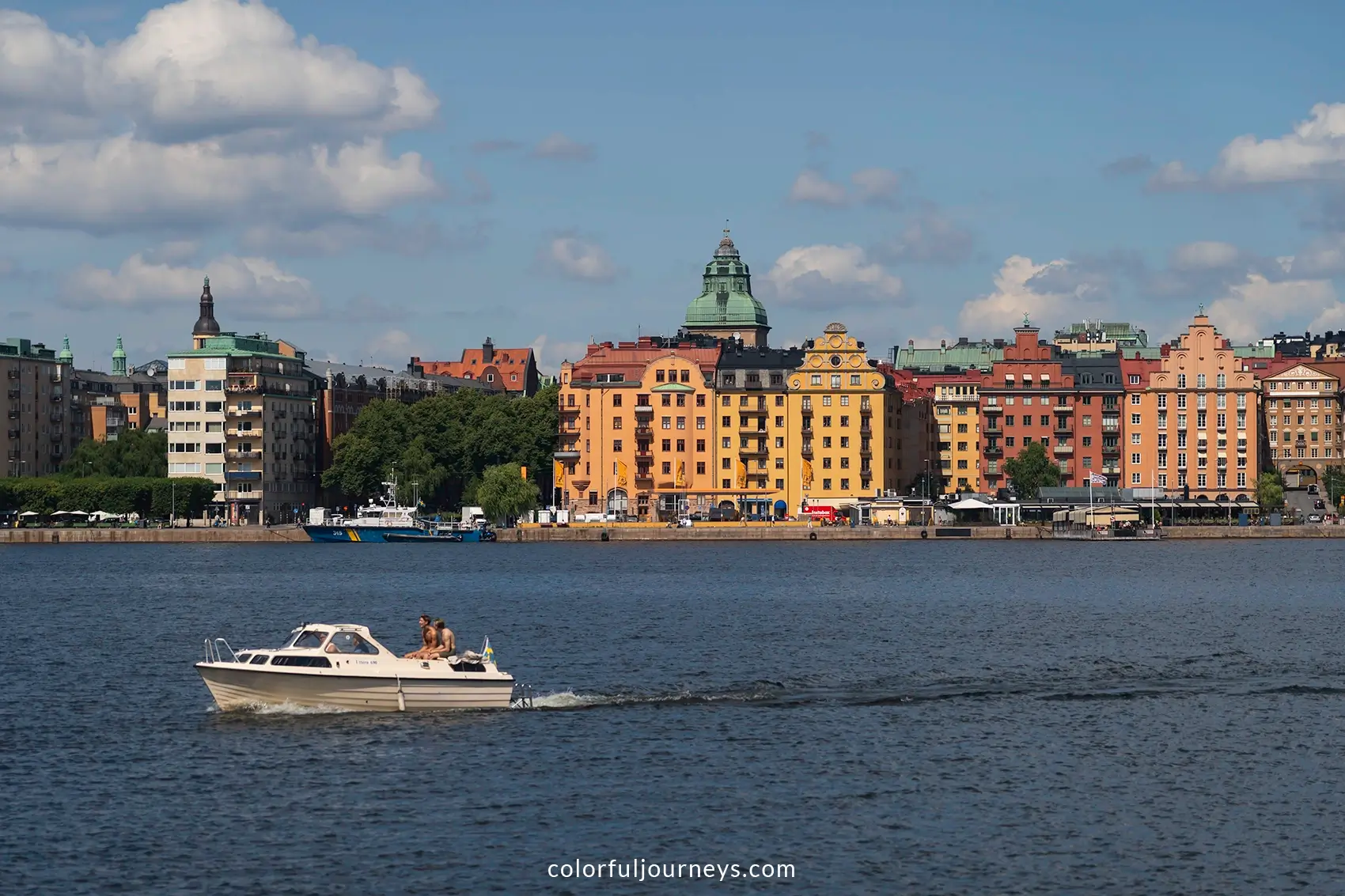 A boat in front of the pastel colored buildings of Stockholm, Sweden
