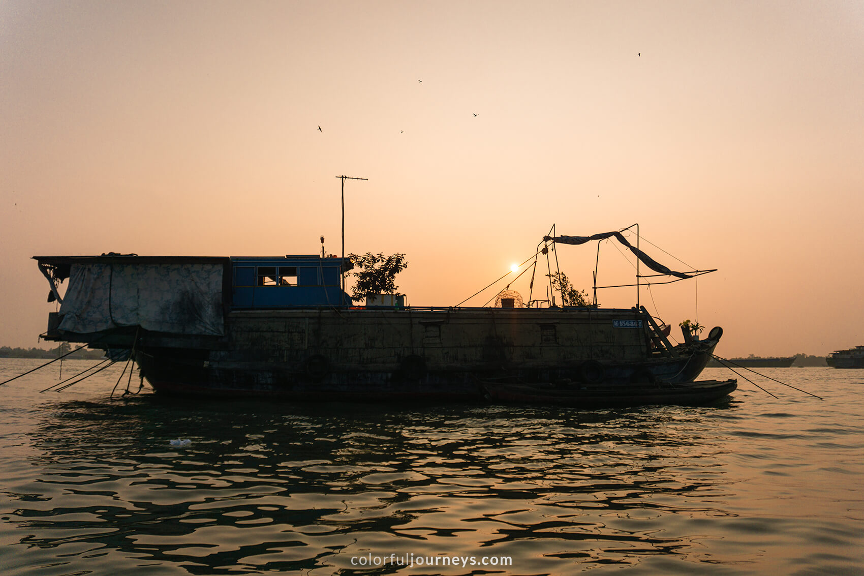 The sun rises behind a boat in Long Xuyen, Vietnam.