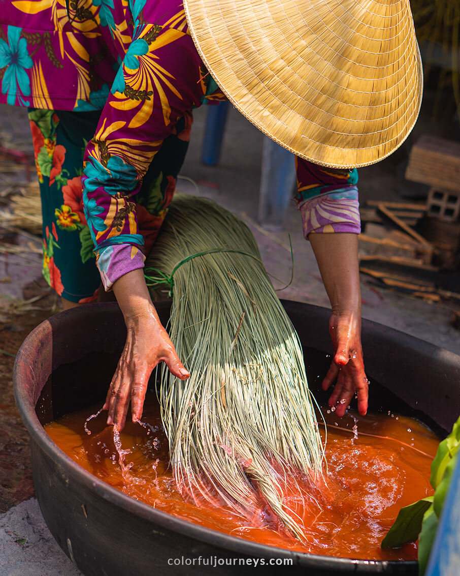A woman dyes mats in Dinh Yen mat village.
