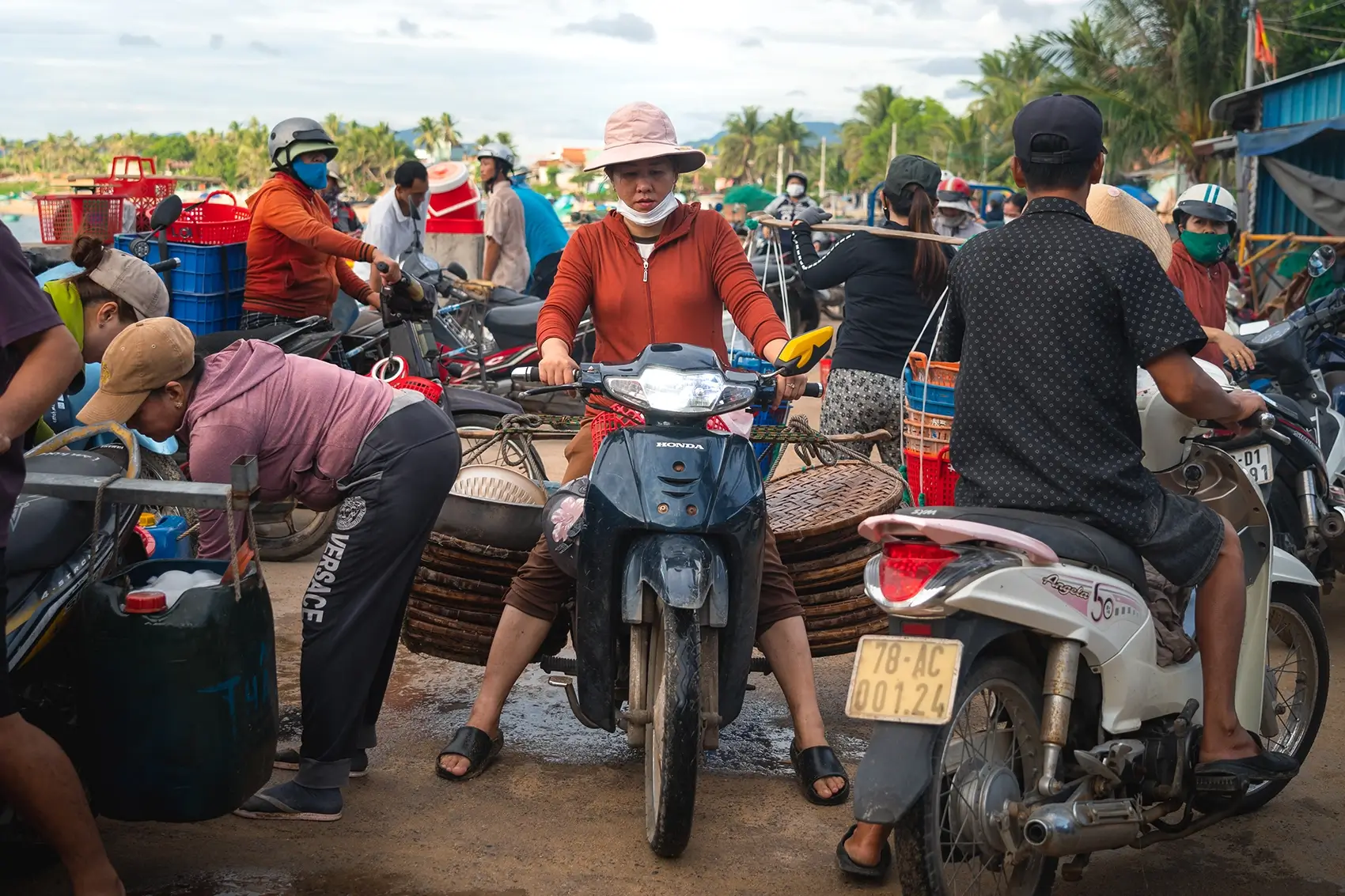 People navigate motorbikes at the Xuan Hai Fish market in Vietnam.