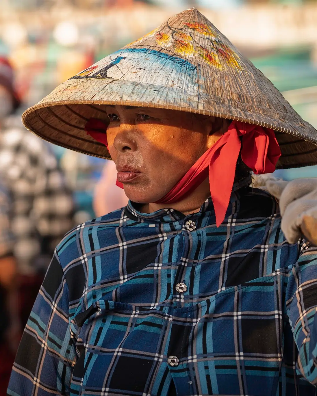 A woman wearing a conical hat on a beach in Vietnam