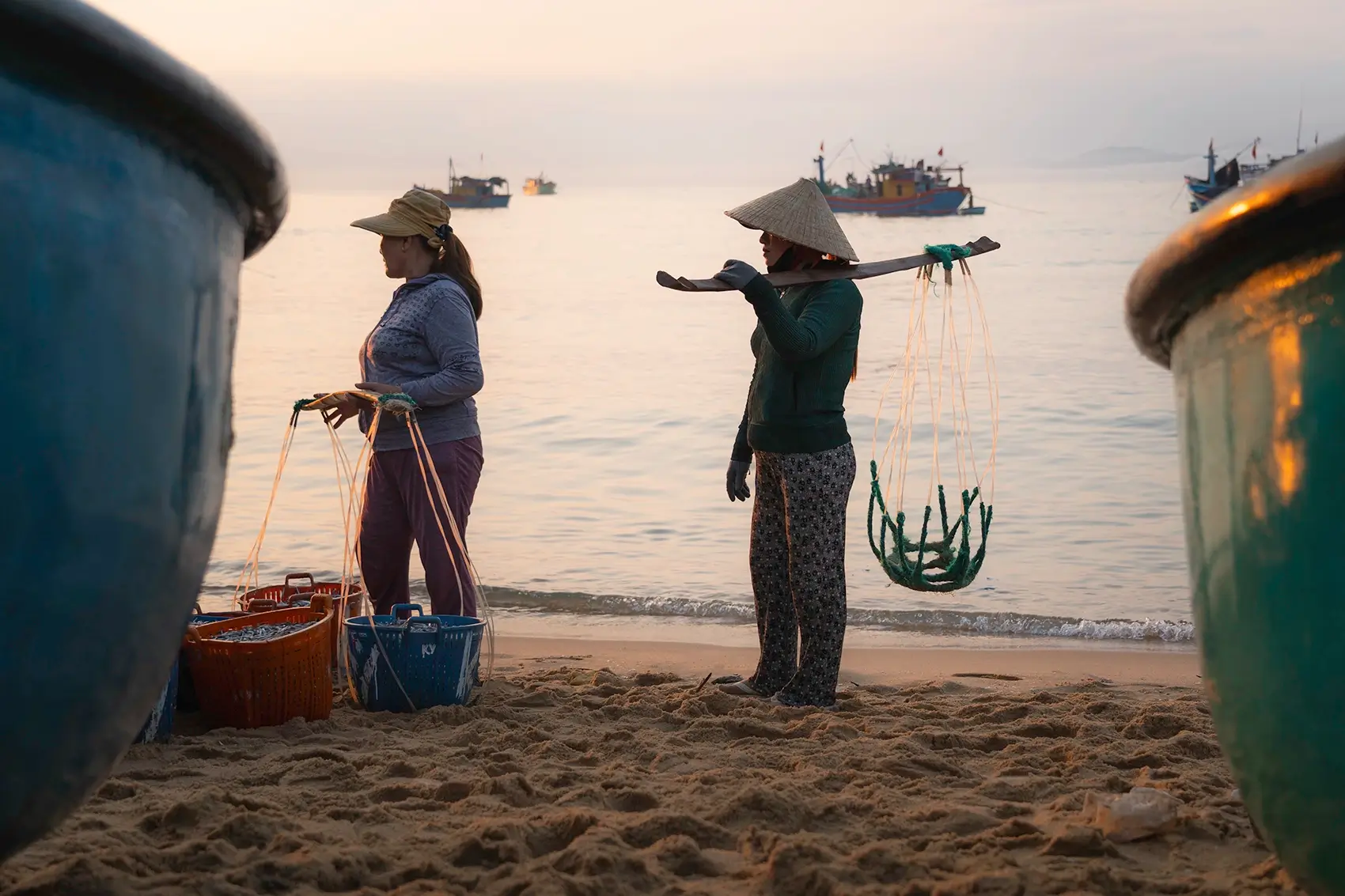 Women stand on a beach in Xuan Hai, Vietnam