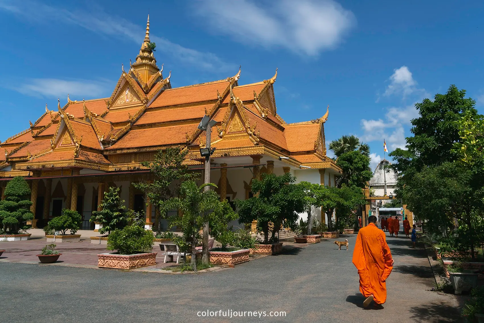 A monke in an orange robe at Kampong Ksan temple in Tra Vinh, Vietnam