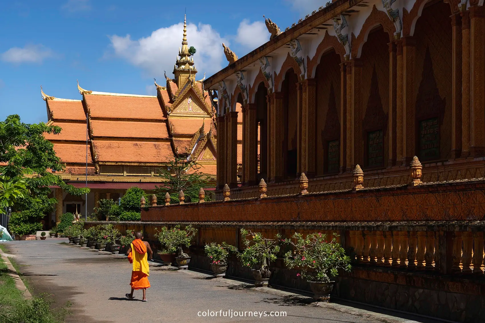 A monk in an orange robe at Kampong Ksan temple in Tra Vinh, Vietnam