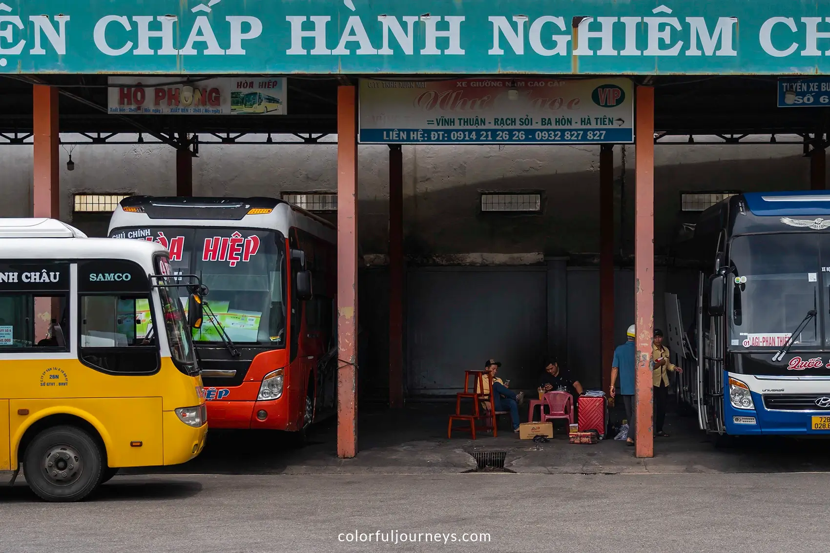 A yellow, blue and red bus at a bus stop in Vung Tau, Vietnam