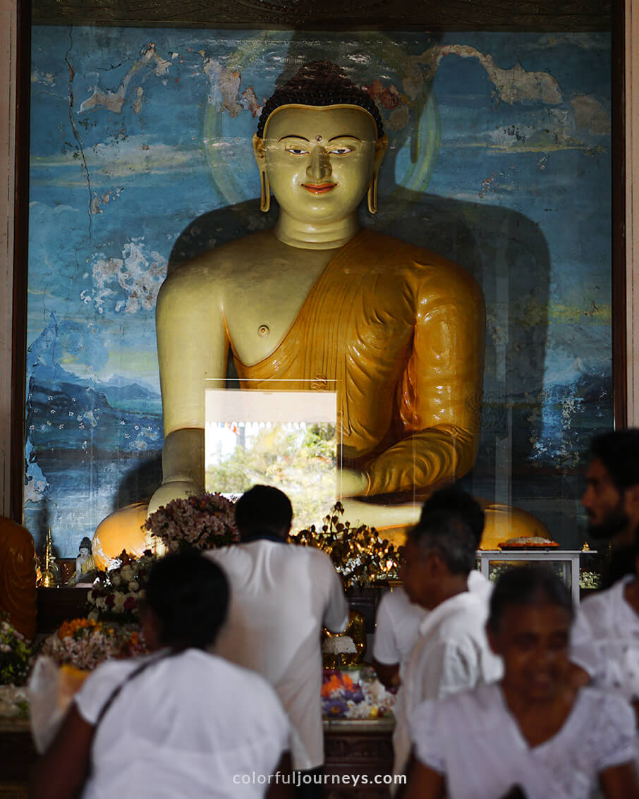 People pray in front of a Buddha statue in Anuradhapura, Sri Lanka