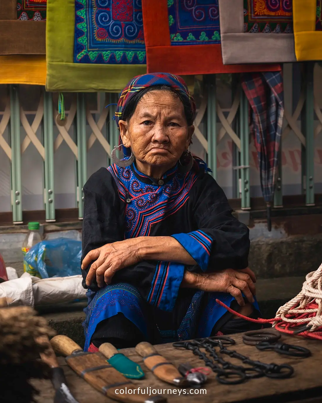 A woman wearing traditional clothes sells tools at the Bac Ha Market in Vietnam