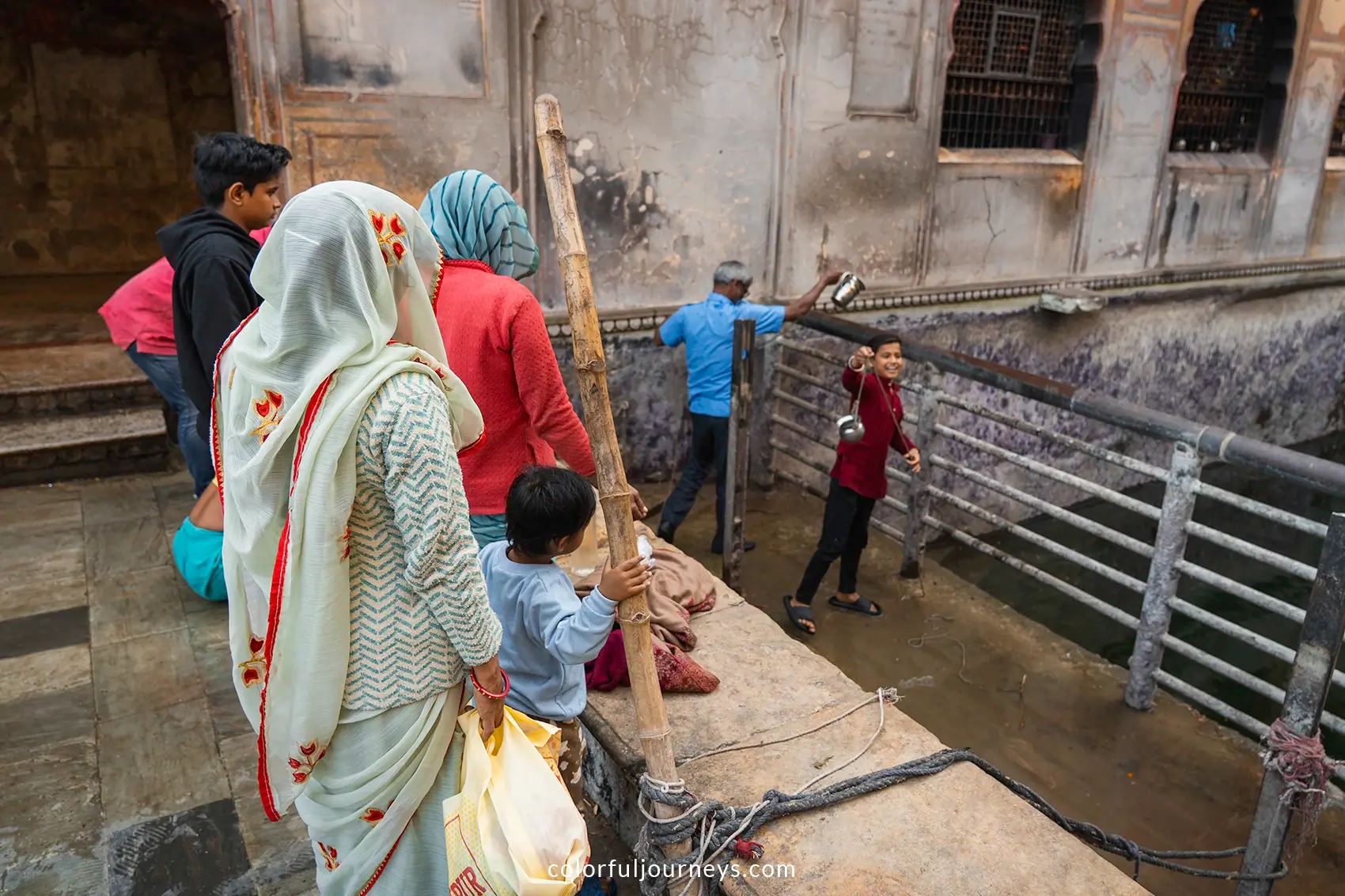 People are collecting water from a sacred pool at the Monkey Temple in Jaipur