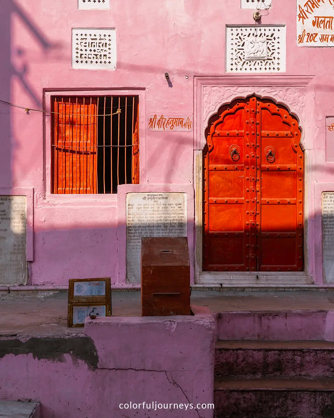 A red door in a pink wall at the Monkey Temple in Jaipur, India