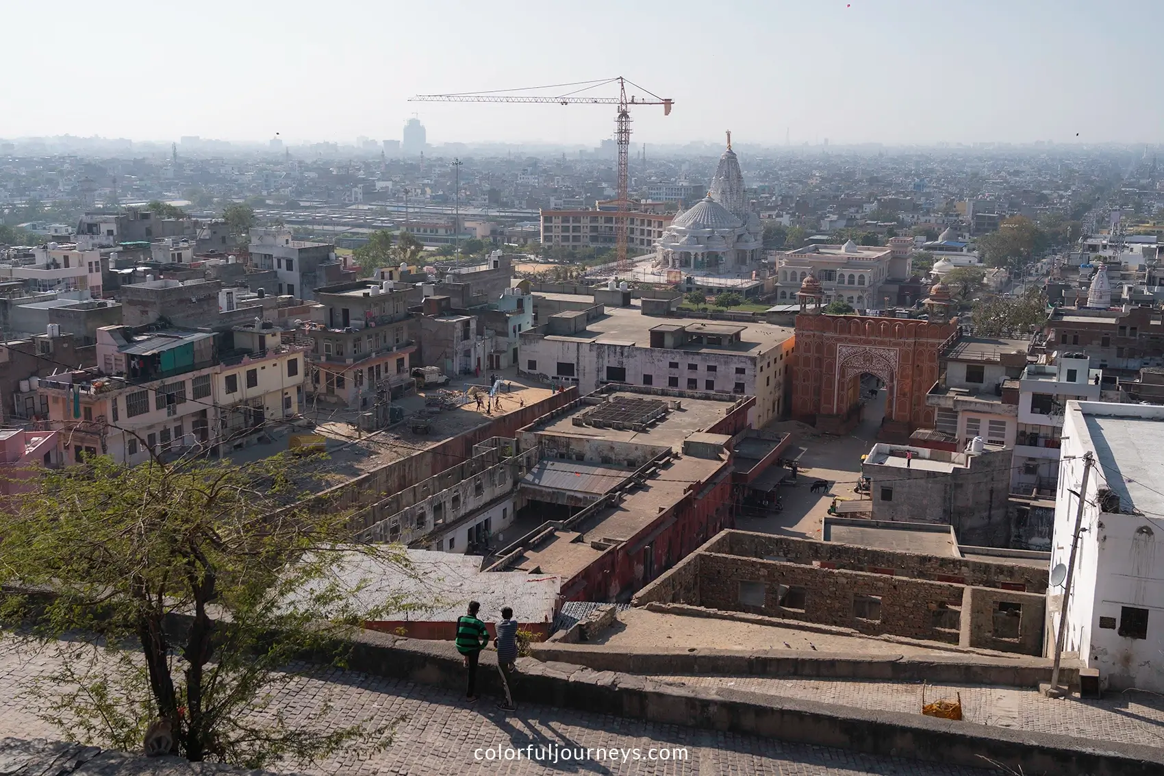 Men look out over Galta Gate and Jaipur in  he distance