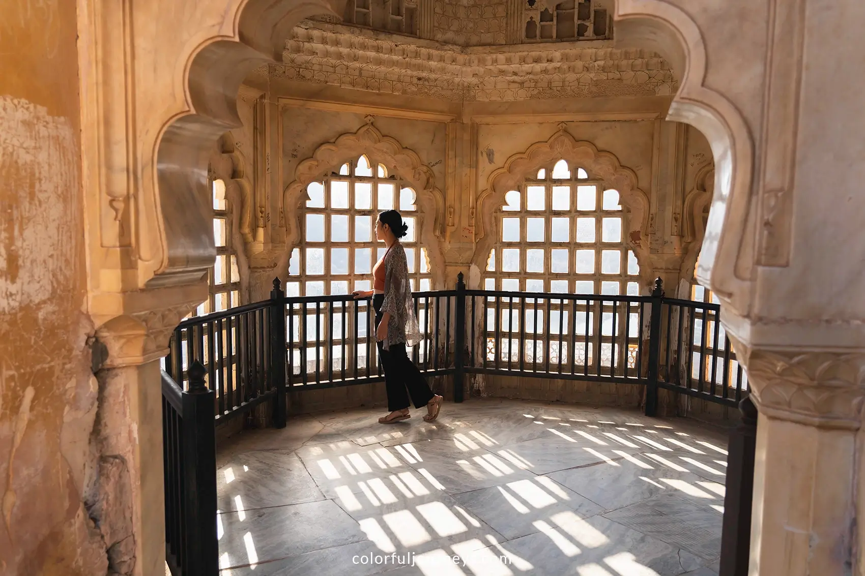A woman looks through a window at Amer Fort in Jaipur, India