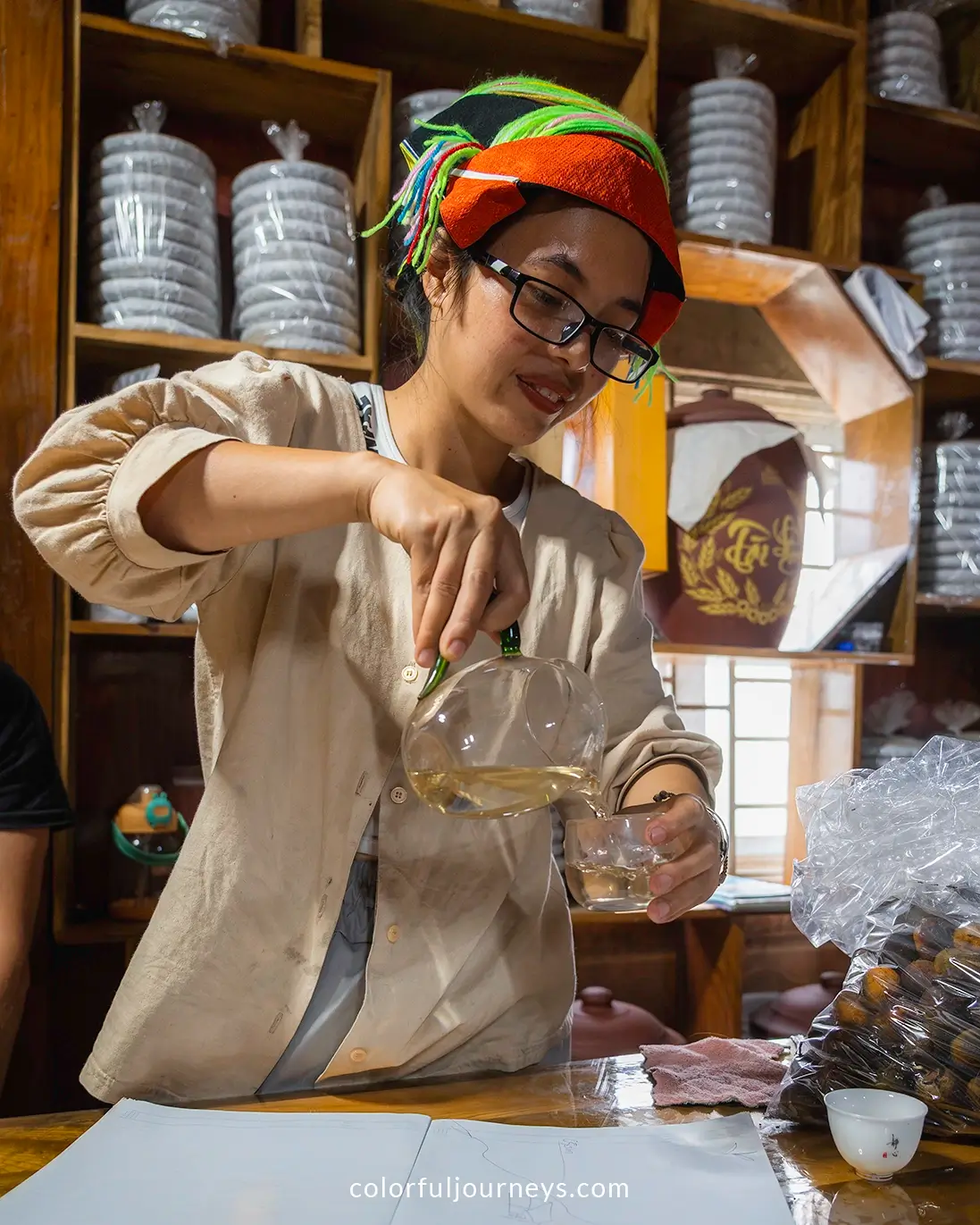 A woman wearing traditional Dao clothes prepares tea in Vietnam