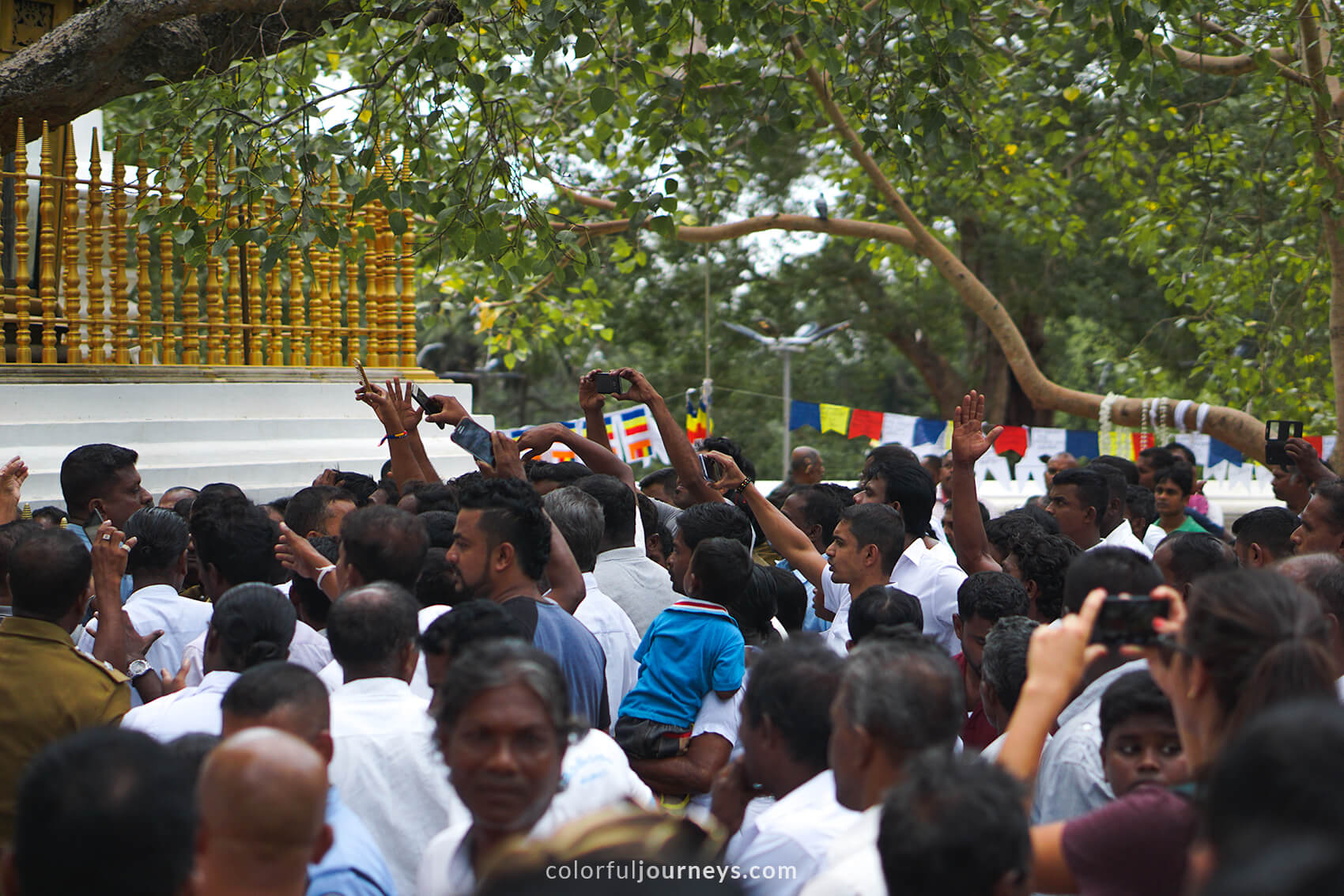 A crowd of people gathers at a temple in Anuradhapura, Sri Lanka.