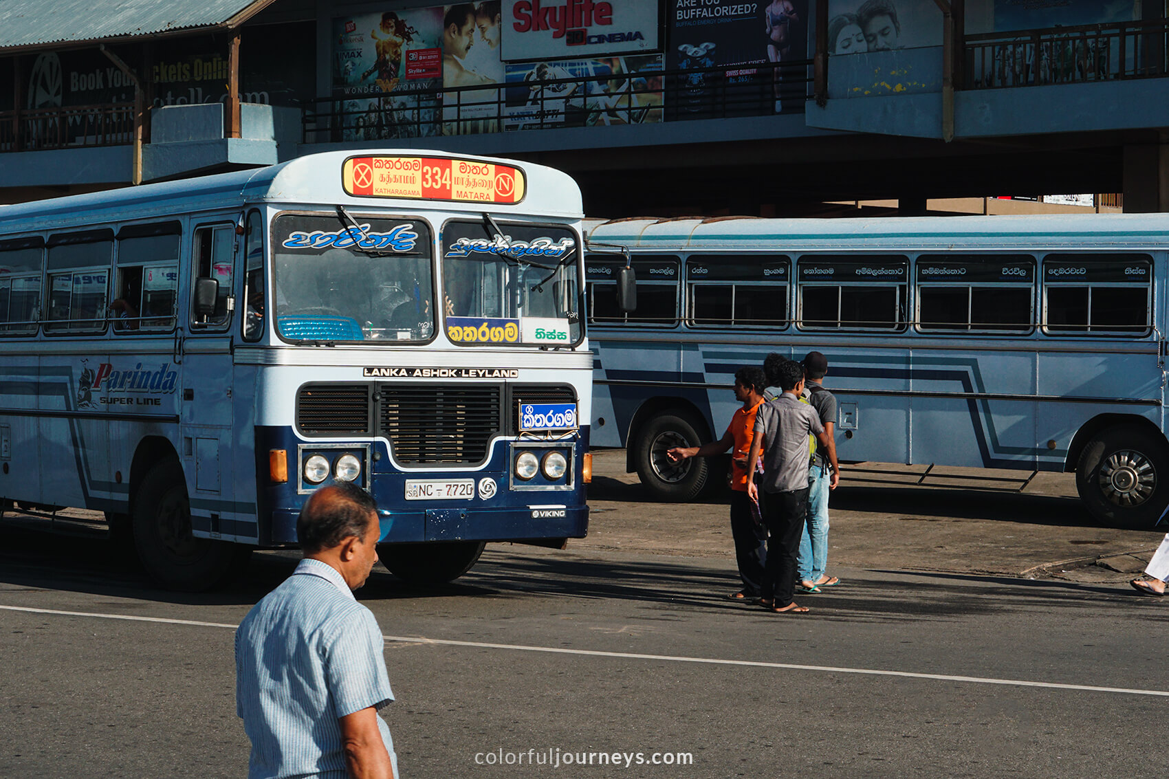 Commuters manoeuvre inbeween busses at Matara bus station, Sri Lanka. 