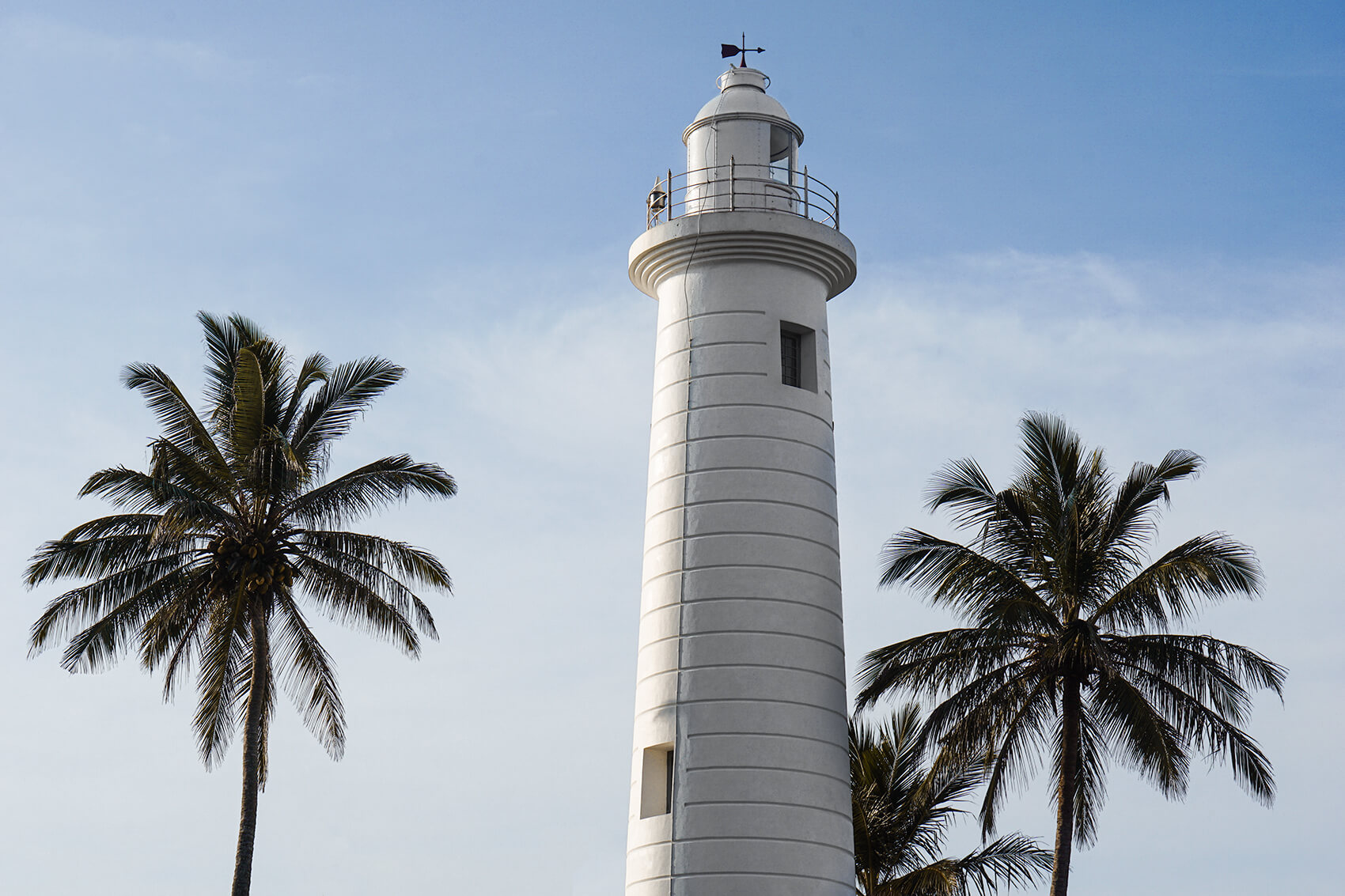 Galle lighthouse against a blue sky. 