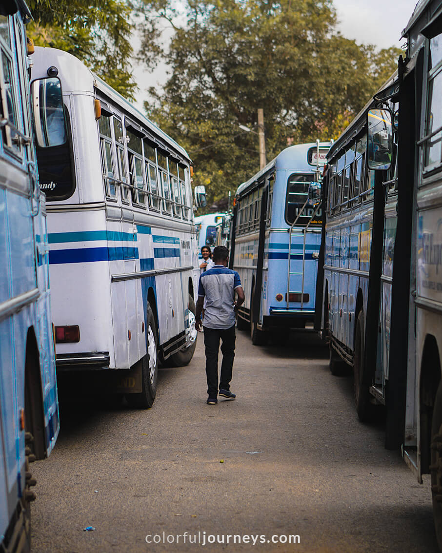 A man walks in between busses at Kandy bus station, Sri Lanka.