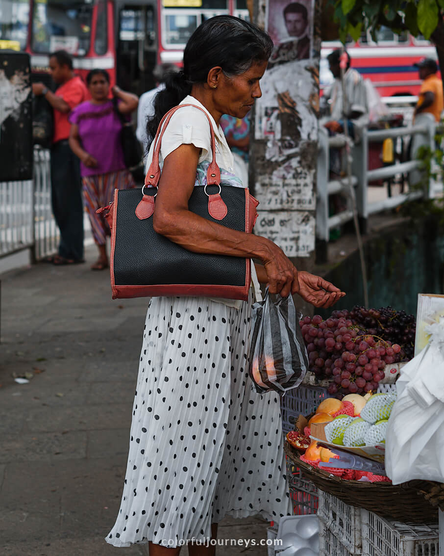 A woman buys goods at a local market in Kandy, Sri Lanka.