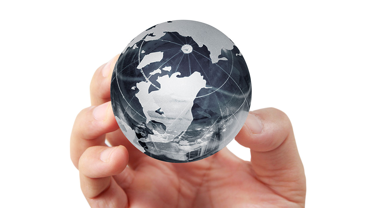 Color close-up of hand holding glass globe.