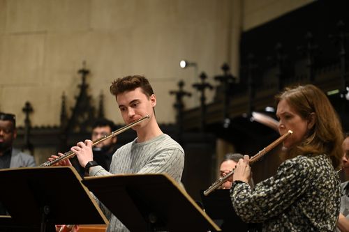 A man and a woman play flute together