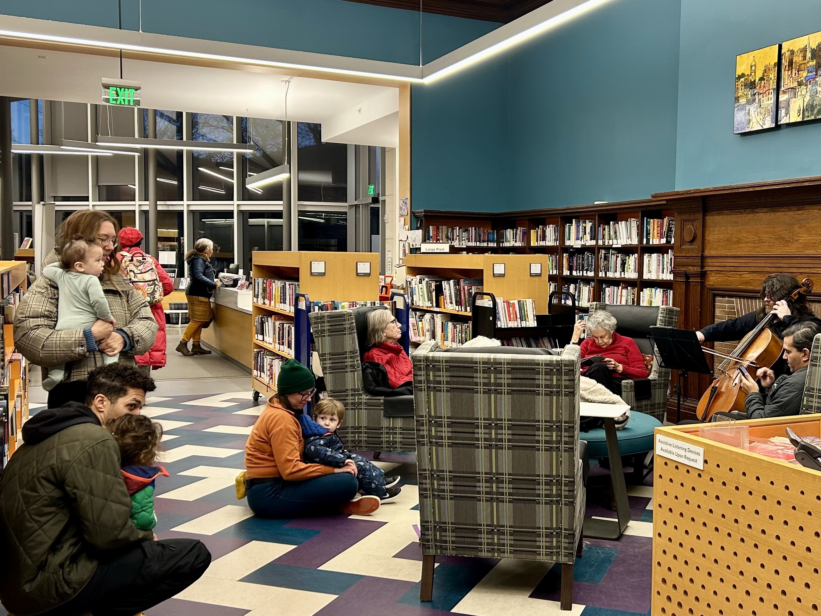 A man plays cello in a library for parents and children