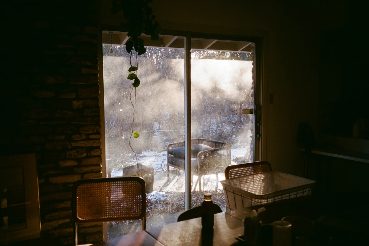A dim empty house with light coming through the window door.