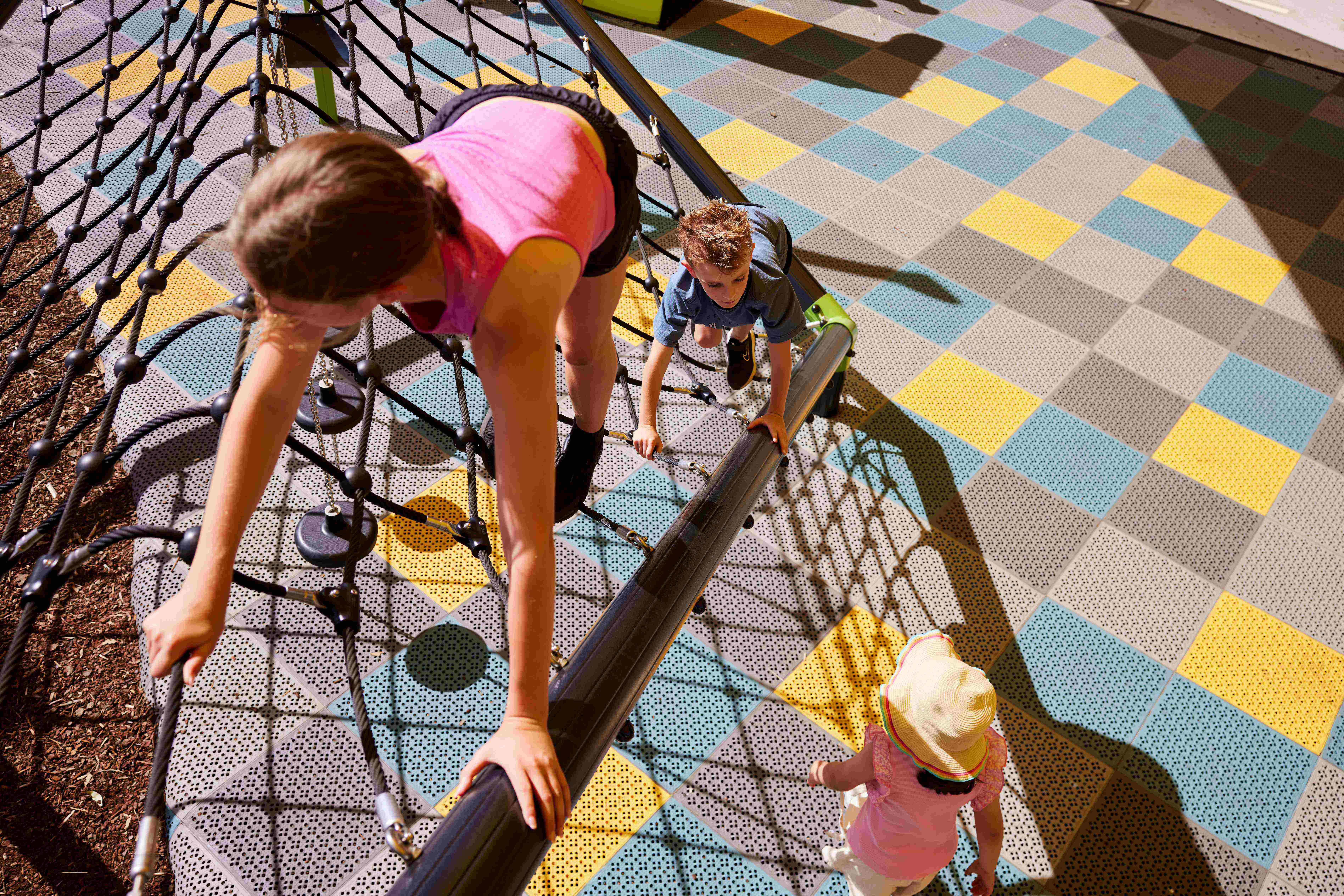Boy toddler on playground slide above safety surface
