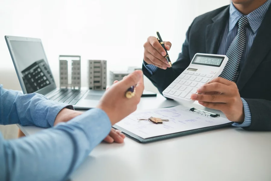 Financial advisor shows couple numbers on a calculator