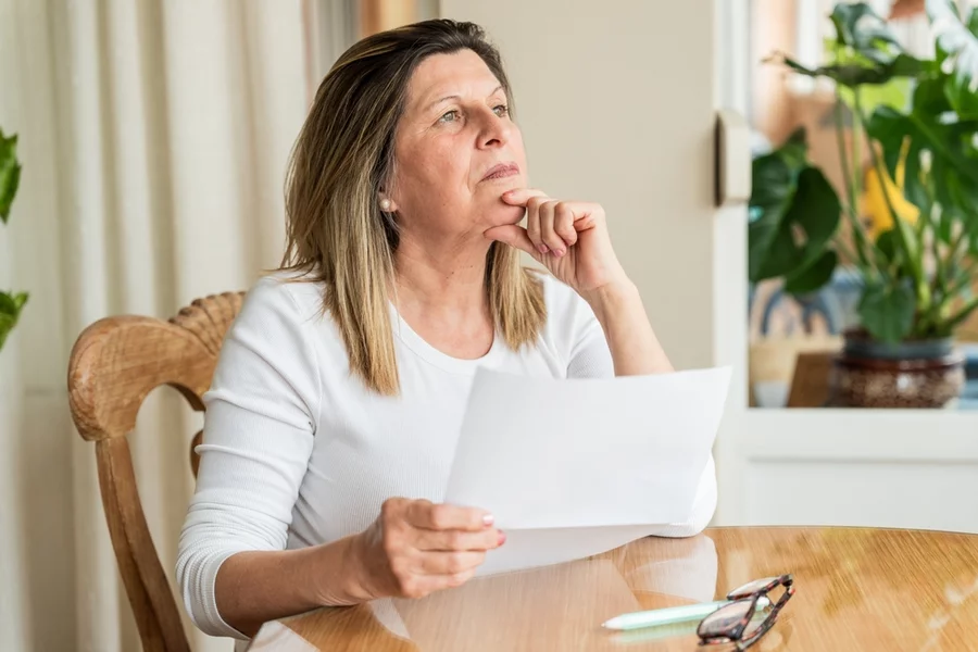 Older woman sitting and reviewing financial documents