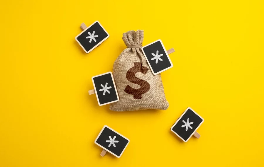 Money bag with signs symbolizing hidden fees surrounding it