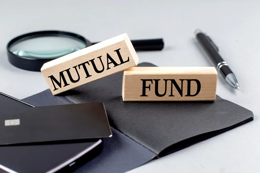 MUTUAL FUND text on a wooden block on black notebook , business concept